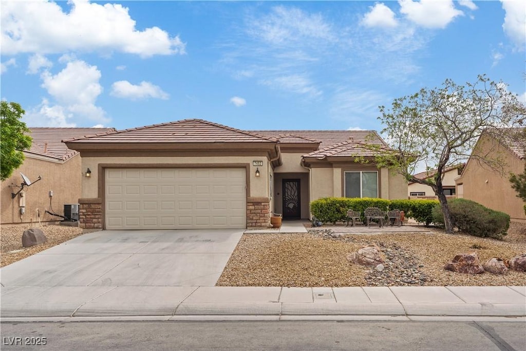 view of front of house featuring central AC, a tiled roof, an attached garage, concrete driveway, and stucco siding