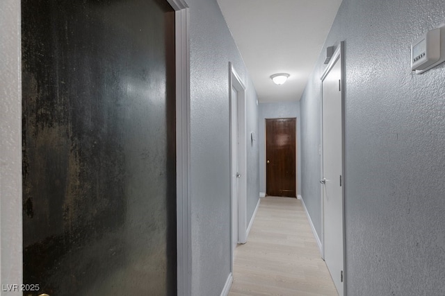 1643 E St, Las Vegas, NV 89106 - hall with light wood-style floors, a textured wall, and baseboards