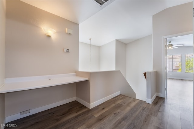 hall featuring wood finished floors, baseboards, and an upstairs landing