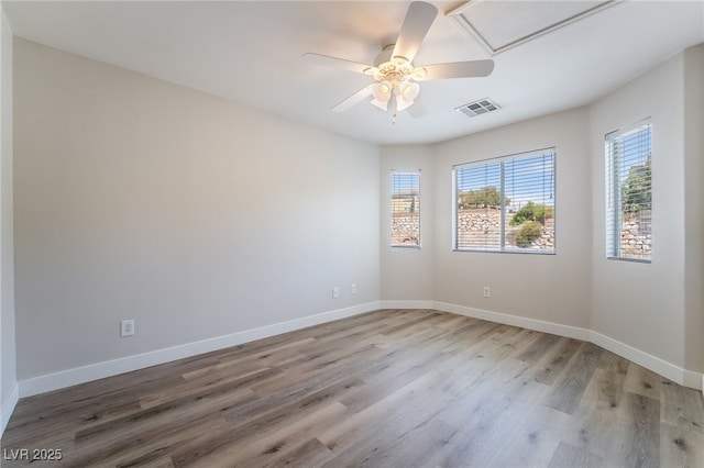 empty room with light wood-type flooring, ceiling fan, and baseboards