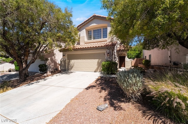 mediterranean / spanish-style house featuring a tiled roof, stucco siding, driveway, and an attached garage