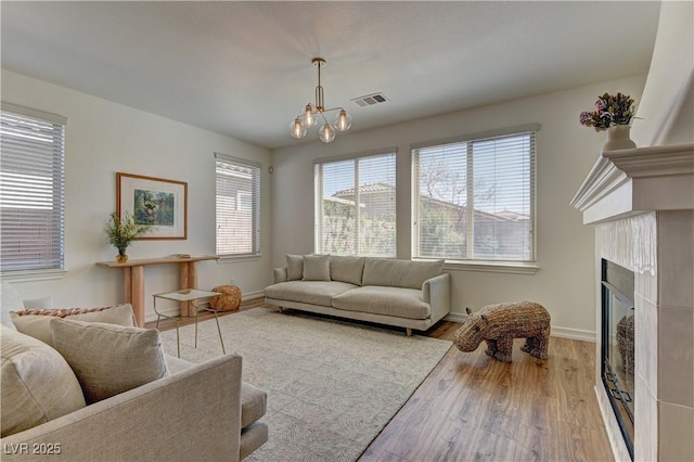 9992 Sky Parlor Rd, Las Vegas, NV 89178 - living area with visible vents, baseboards, a chandelier, a fireplace, and wood finished floors
