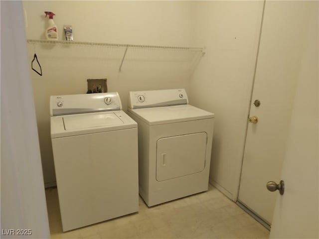 washroom with washing machine and clothes dryer, light floors, and laundry area