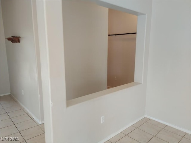 interior space featuring light tile patterned floors and baseboards