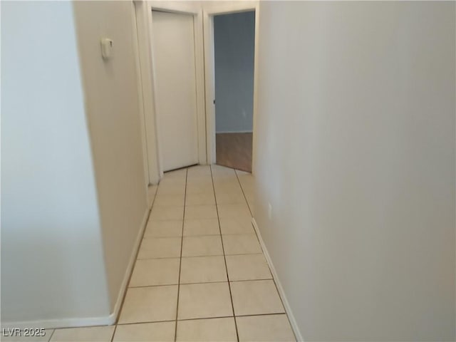 hall with baseboards and tile patterned flooring