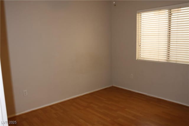 unfurnished room with wood finished floors and baseboards