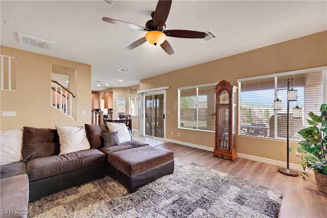 living area featuring wood finished floors, baseboards, and visible vents