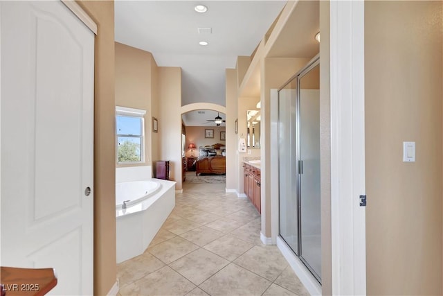 full bath with ensuite bathroom, a shower stall, vanity, a ceiling fan, and tile patterned flooring