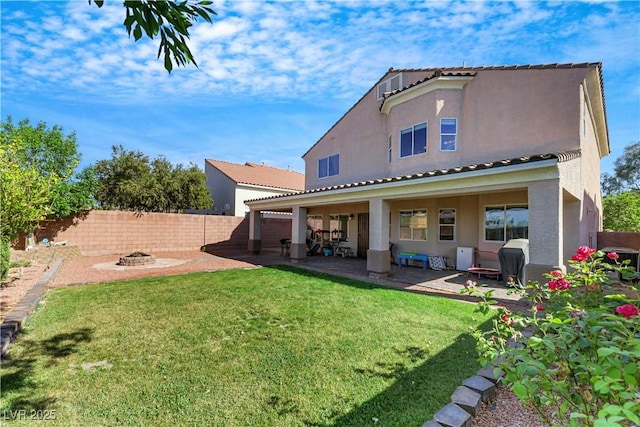 back of house featuring stucco siding, a patio area, a fenced backyard, an outdoor fire pit, and a yard