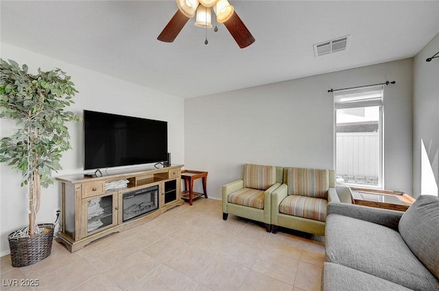 living area with visible vents, a ceiling fan, and light tile patterned flooring
