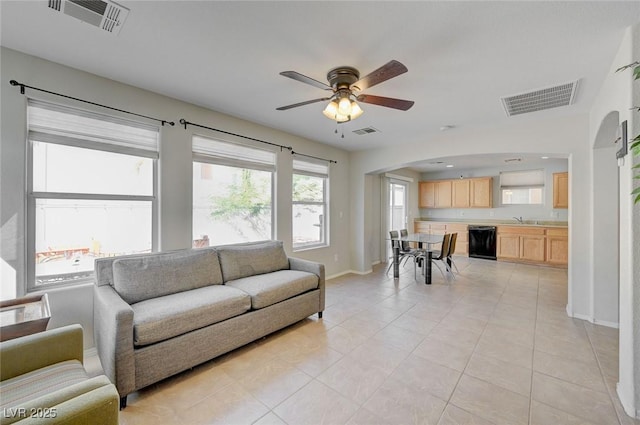 living room with visible vents, ceiling fan, and arched walkways