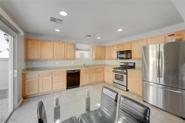 kitchen with visible vents, a sink, light countertops, light brown cabinetry, and black appliances