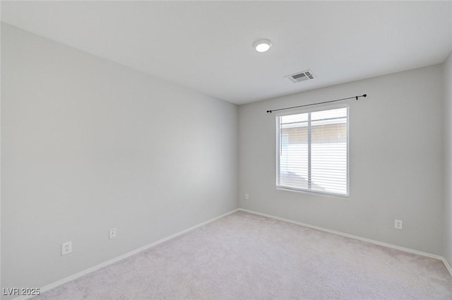 spare room featuring carpet flooring, visible vents, and baseboards