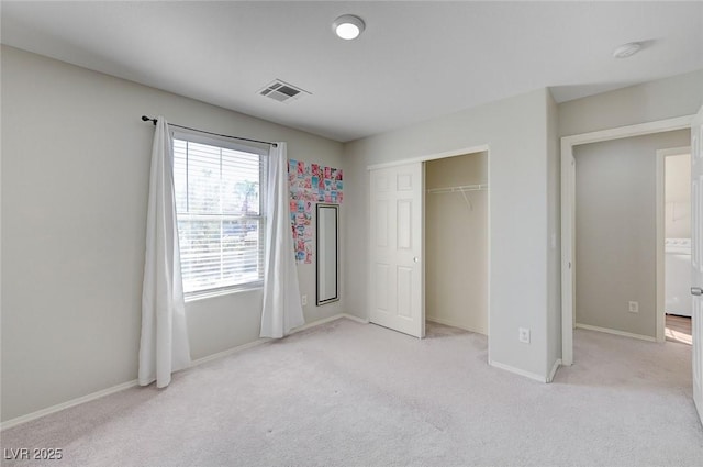 unfurnished bedroom featuring visible vents, baseboards, a closet, and light carpet