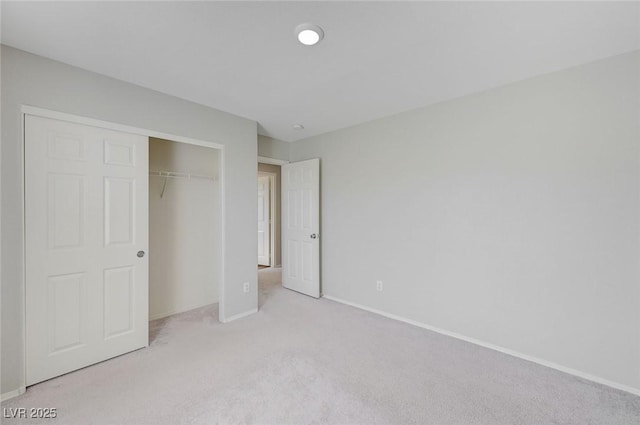 unfurnished bedroom with carpet floors, baseboards, and a closet