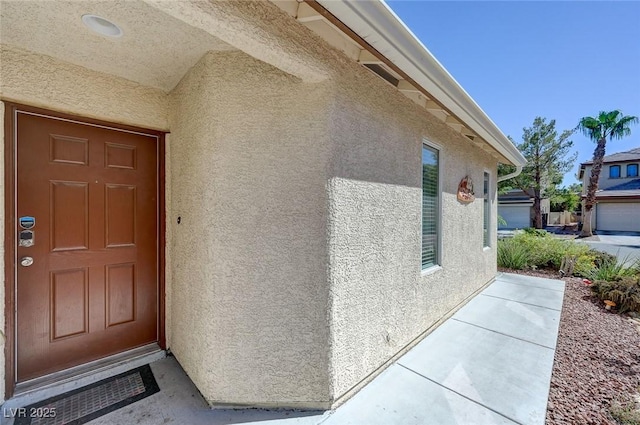 property entrance with stucco siding