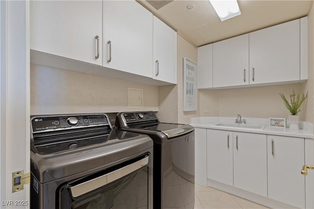 laundry area featuring a sink, cabinet space, separate washer and dryer, and light tile patterned flooring