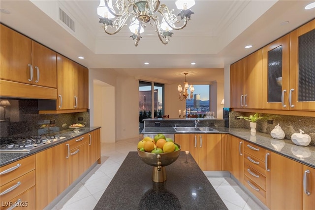 2877 Paradise Rd Unit 2502, Las Vegas, NV 89109 - kitchen featuring a chandelier, a sink, stainless steel gas cooktop, decorative backsplash, and light tile patterned floors