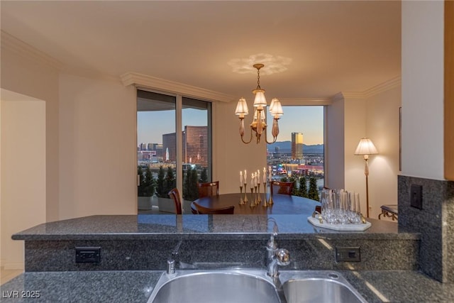 2877 Paradise Rd Unit 2502, Las Vegas, NV 89109 - kitchen featuring a chandelier, a view of city, a sink, crown molding, and decorative light fixtures