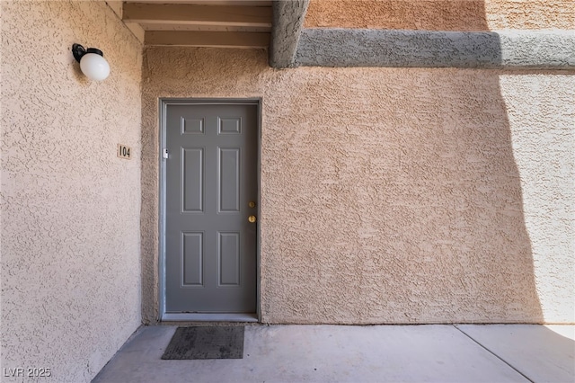 doorway to property with stucco siding