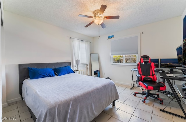 bedroom featuring light tile patterned floors, a textured ceiling, a ceiling fan, and baseboards