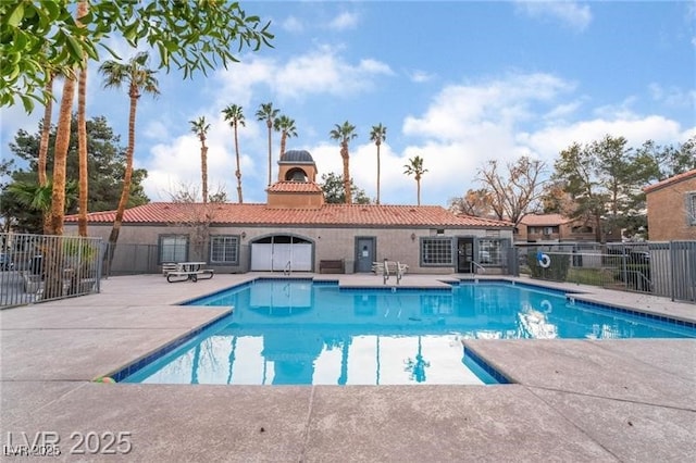 community pool with a patio and fence