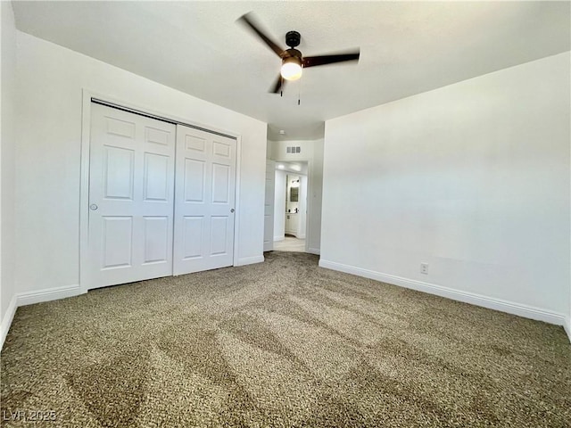 unfurnished bedroom with carpet, a closet, a ceiling fan, visible vents, and baseboards