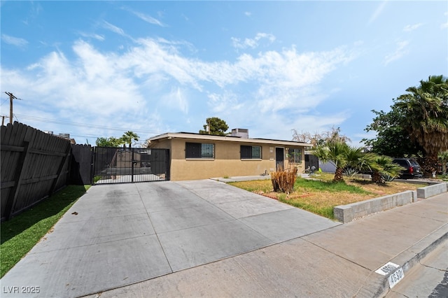 4630 Gabriel Dr, Las Vegas, NV 89121 - view of front facade featuring fence, driveway, stucco siding, and a gate