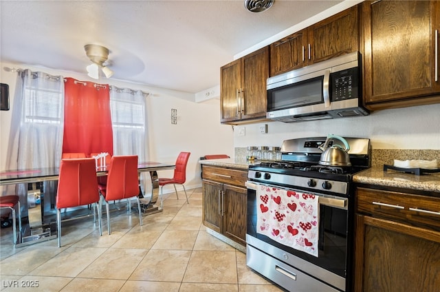 4630 Gabriel Dr, Las Vegas, NV 89121 - kitchen with appliances with stainless steel finishes, light tile patterned floors, dark brown cabinets, and a ceiling fan