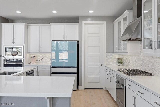 8440 Footpath St, Las Vegas, NV 89166 - kitchen with stainless steel appliances, a sink, white cabinets, light wood-type flooring, and recessed lighting