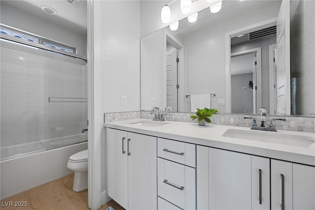 8440 Footpath St, Las Vegas, NV 89166 - bathroom featuring toilet, double vanity, wood finished floors, and shower / bath combination with glass door