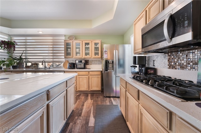 9000 Cotton Rose Way, Las Vegas, NV 89134 - kitchen with glass insert cabinets, light countertops, appliances with stainless steel finishes, dark wood-style floors, and decorative backsplash