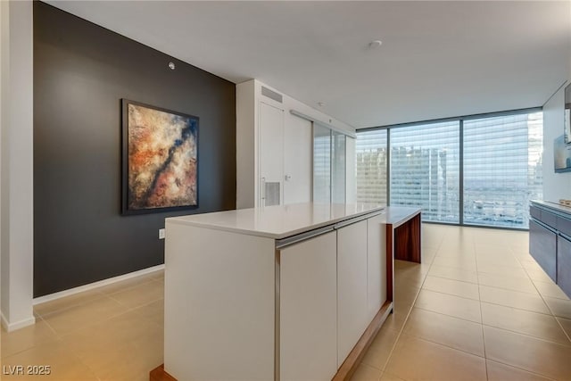 corridor featuring light tile patterned floors and baseboards