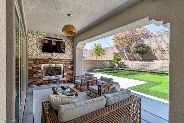 257 Elder View Dr, Las Vegas, NV 89138 - fenced backyard with an outdoor living space with a fireplace, a patio, and a putting area