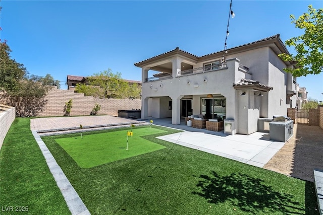 257 Elder View Dr, Las Vegas, NV 89138 - back of house with a putting green, a balcony, stucco siding, an outdoor hangout area, and a patio
