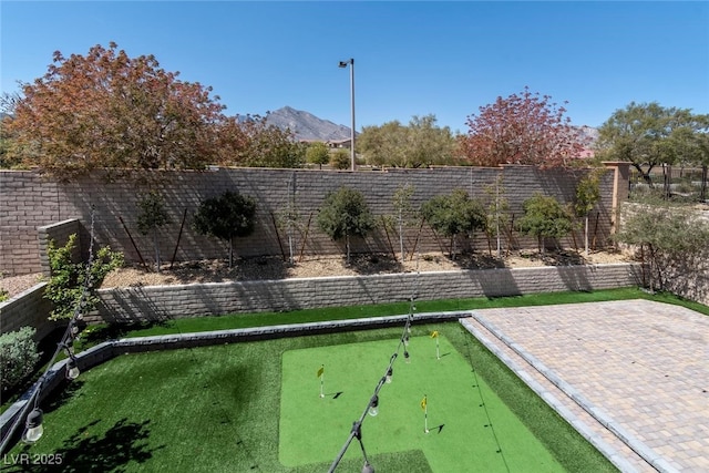 257 Elder View Dr, Las Vegas, NV 89138 - fenced backyard featuring a putting area, a mountain view, and a patio area