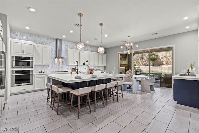 257 Elder View Dr, Las Vegas, NV 89138 - kitchen featuring wall chimney range hood, light countertops, recessed lighting, a chandelier, and decorative backsplash