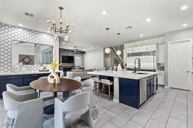 257 Elder View Dr, Las Vegas, NV 89138 - kitchen with blue cabinetry, open floor plan, light countertops, appliances with stainless steel finishes, and ceiling fan