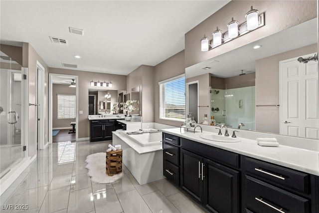 257 Elder View Dr, Las Vegas, NV 89138 - full bathroom with a shower stall, a bathtub, ceiling fan, two vanities, and marble look tiles