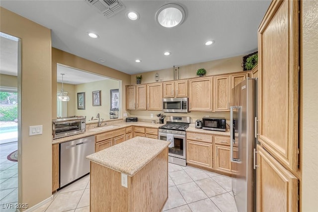 1862 Redwood Valley St, Henderson, NV 89052 - kitchen featuring light brown cabinetry, appliances with stainless steel finishes, a sink, and a center island
