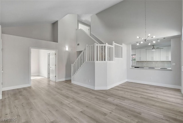 2212 Warm Walnut Dr, Las Vegas, NV 89134 - unfurnished living room with stairway, high vaulted ceiling, a chandelier, light wood finished floors, and baseboards