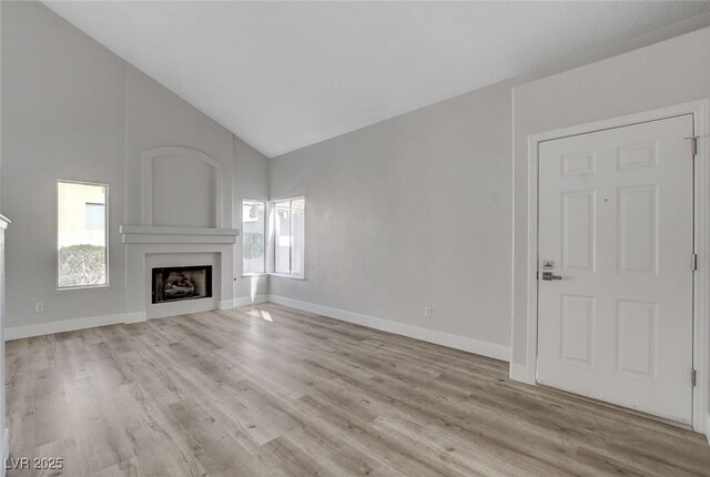 2212 Warm Walnut Dr, Las Vegas, NV 89134 - unfurnished living room with a fireplace, wood finished floors, high vaulted ceiling, and baseboards