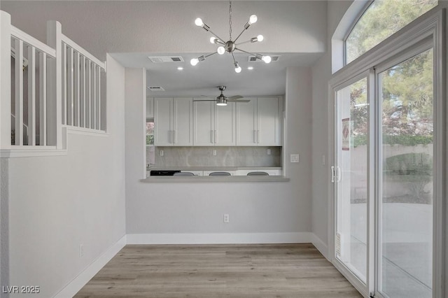 2212 Warm Walnut Dr, Las Vegas, NV 89134 - unfurnished dining area featuring ceiling fan, a chandelier, light wood-style floors, and baseboards