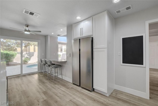 2212 Warm Walnut Dr, Las Vegas, NV 89134 - kitchen with freestanding refrigerator, baseboards, white cabinets, ceiling fan, and light wood finished floors