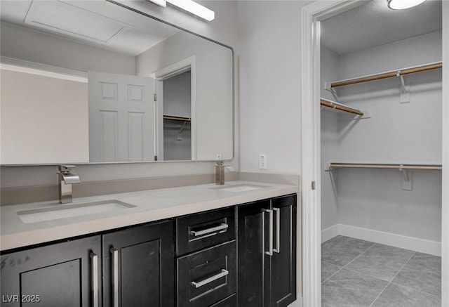 2212 Warm Walnut Dr, Las Vegas, NV 89134 - bathroom featuring baseboards, double vanity, tile patterned floors, and a spacious closet