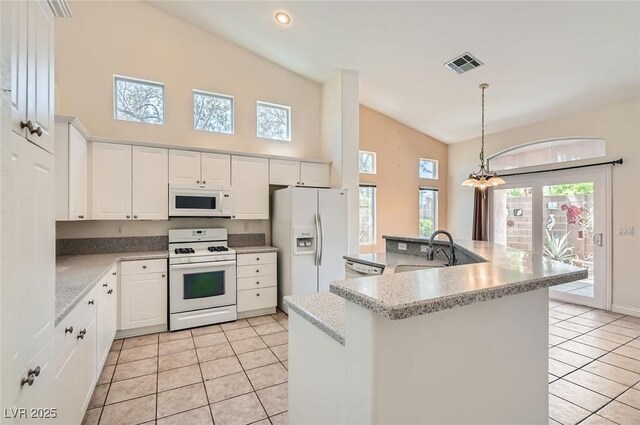 kitchen featuring light tile patterned floors, white appliances, a sink, and visible vents