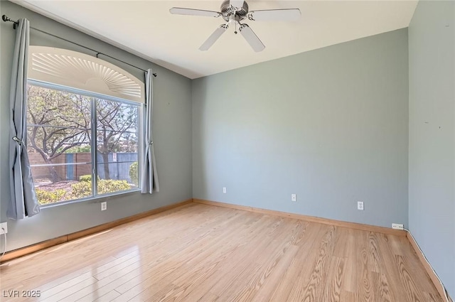 spare room with baseboards, ceiling fan, and wood finished floors