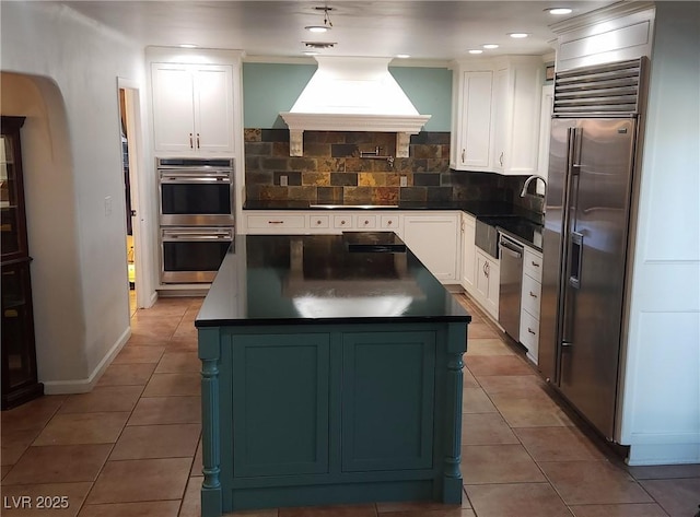 5312 Manuel Dr, Las Vegas, NV 89149 - kitchen with a sink, island range hood, decorative backsplash, dark countertops, and appliances with stainless steel finishes