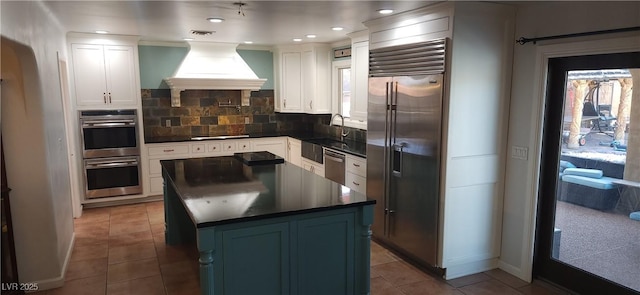 5312 Manuel Dr, Las Vegas, NV 89149 - kitchen featuring a sink, custom exhaust hood, tile patterned flooring, dark countertops, and appliances with stainless steel finishes