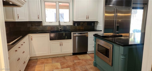 5312 Manuel Dr, Las Vegas, NV 89149 - kitchen featuring dark countertops, white cabinetry, built in appliances, and a sink